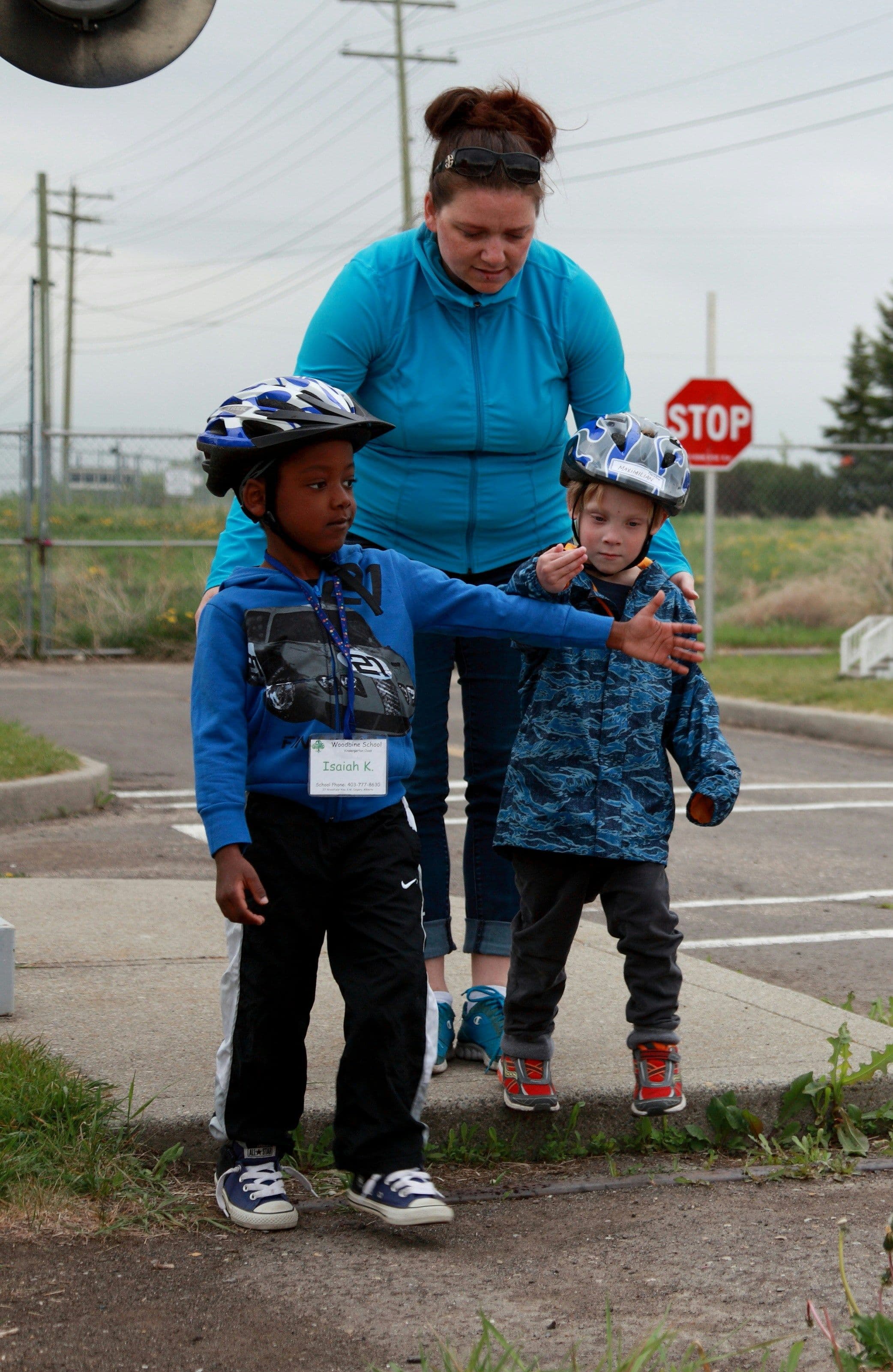 Woman helping two children cross the street.